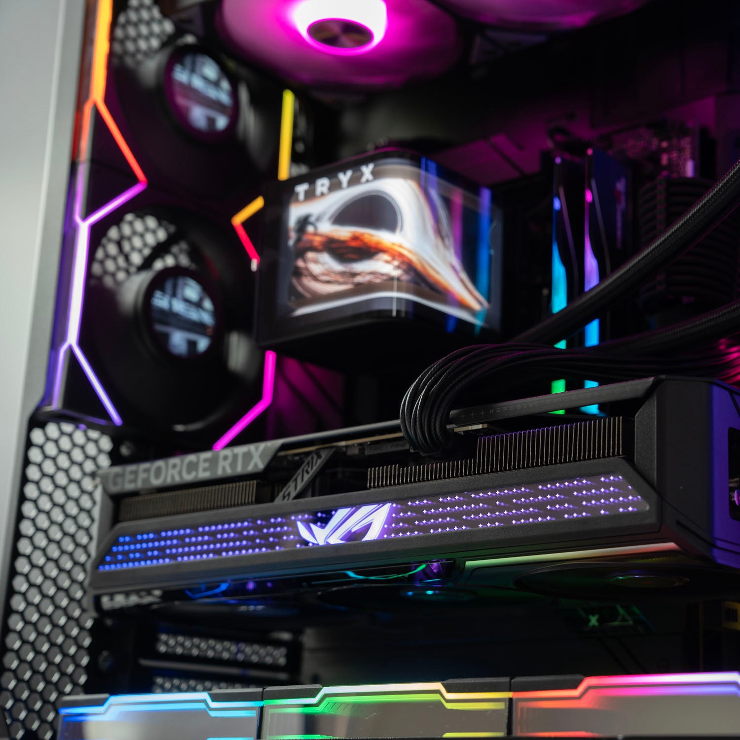 Close-up of a computer case with RGB lighting and visible branding.High-end black panoramic AMD gaming PC with RGB lighting – Ryzen 9 9950X3D with ASUS ROG Strix RTX 5070 Ti 16GB, 64GB DDR5, 2TB SSD, TRYX Panorama 360mm liquid cooler, and multiple Lian Li LCD fans in Lian Li O11 Vision Compact case, designed for smooth 1440p/4K gaming and creative workloads in Australia.