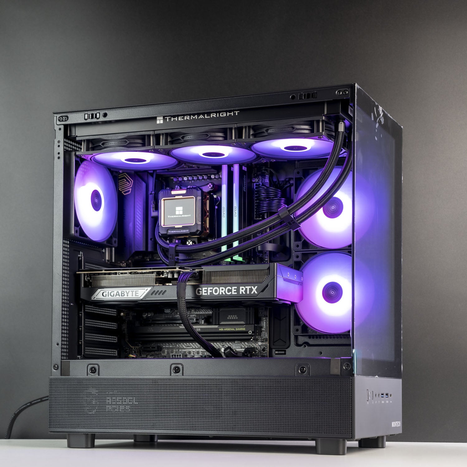 A high-end custom PC build in a black Thermalright tower case with a glass side panel, featuring RGB-lit fans, a Gigabyte RTX graphics card, and a CPU cooler, set against a dark gray background.