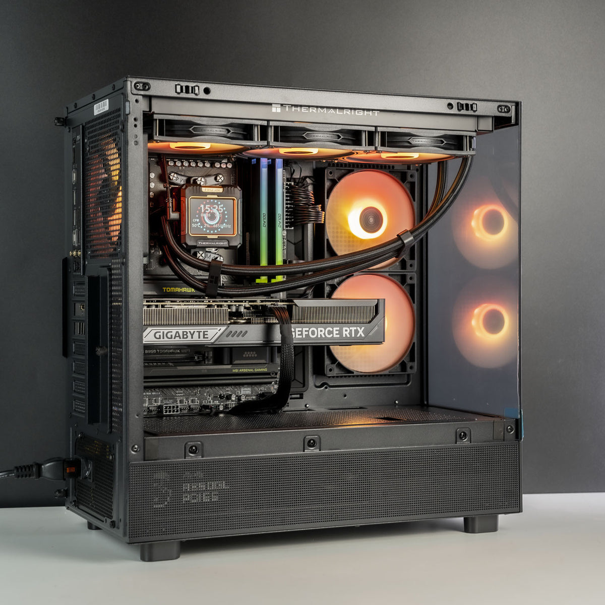 A high-end custom PC tower with a glass side panel, showcasing a liquid CPU cooler, dual Gigabyte GeForce RTX graphics cards, RGB RAM, and glowing circular fans inside a black chassis.
