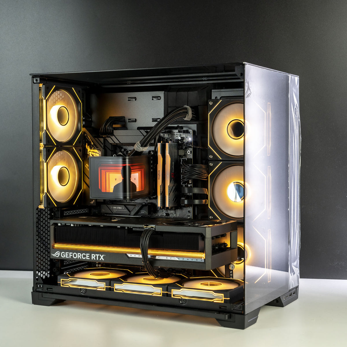 A custom-built desktop computer inside a black mid-tower case with a clear side panel, showcasing an intricate internal setup with glowing yellow and orange RGB fans, a liquid CPU cooler, and a GeForce RTX graphics card, set against a dark gray background.
